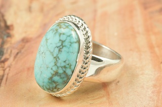 Genuine Number 8 Turquoise set in Sterling Silver Ring. The Number 8 mine is located in Eureka County Nevada. Since 1976 there has been no Number 8 Turquoise mined. There is however, an existing stock pile that Mr. Dowell Ward, the last owner of the Number 8 mine, had stocked away for later sorting. The Turquoise is a collector's item--because once the reserve is gone there will be no more material released onto the market. The Gold Mining Company owns the claim to the Number 8 mine and it has been swallowed up by the gold mining operations. This is some of the last Number 8 Turquoise to be had and will be a great addition to your collection. Created by Navajo Artist Phillip Sanchez. Signed by the artist.